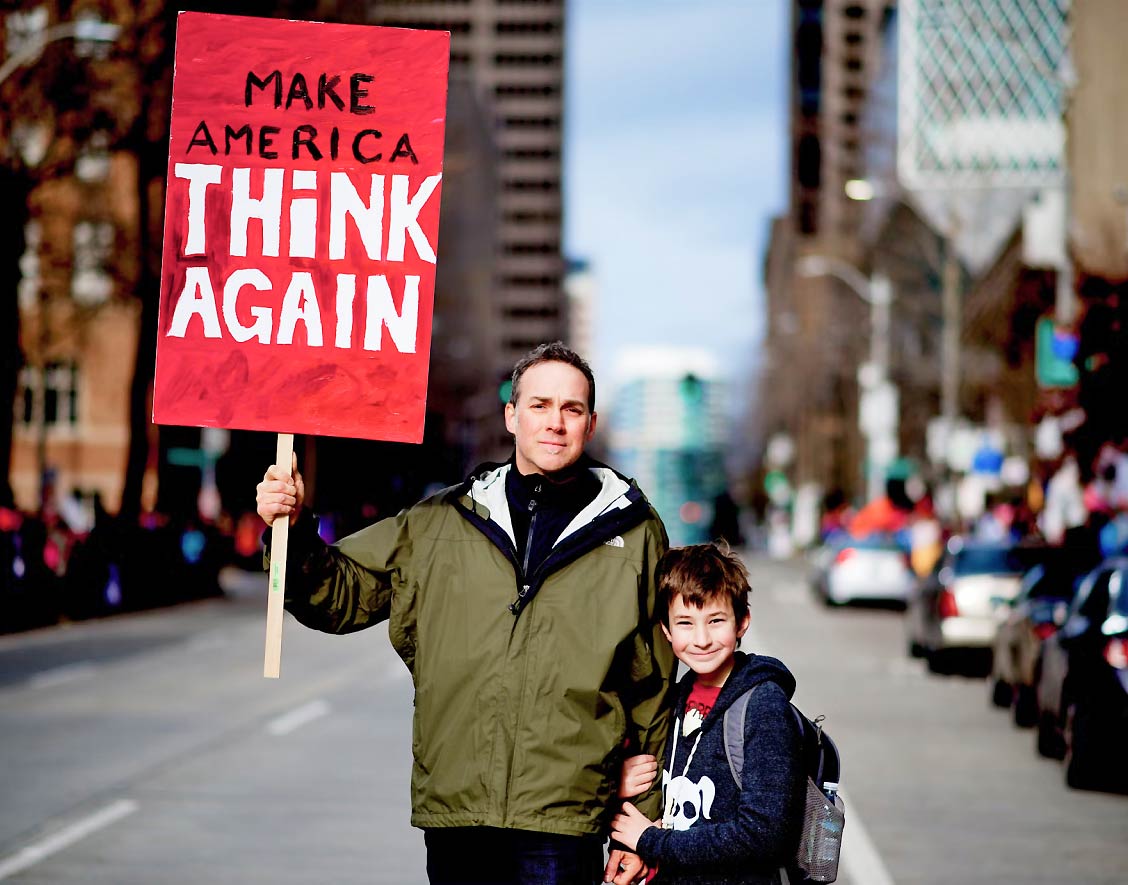 Father and Son in Street Holding up a Sign Father and Son in Street Holding up a Sign